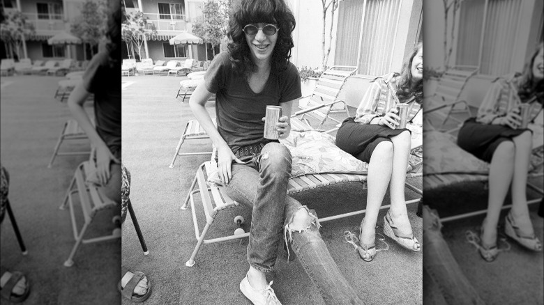 Joey Ramone sitting by pool sunglasses smiling