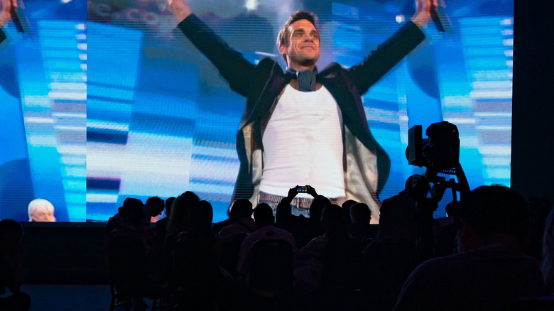 Fans silhouetted screen stage Robbie Williams