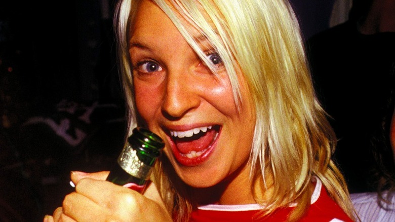 Sia holding a beer bottle and smiling