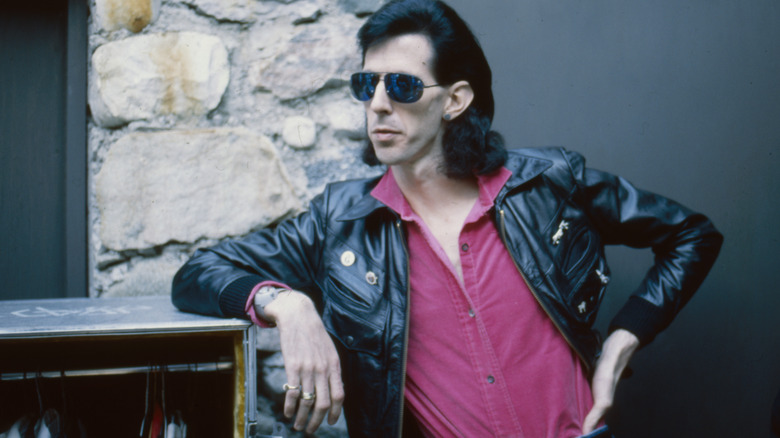 Ric Ocasek leaning on a car 1985