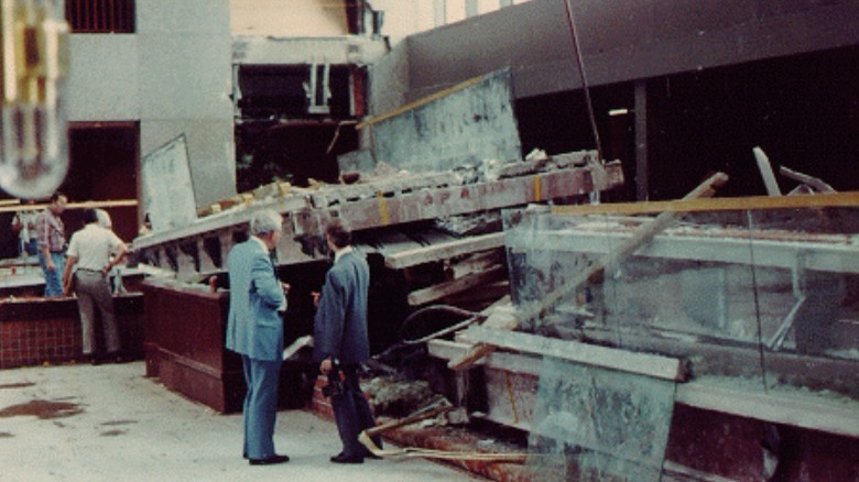 View of Hyatt lobby with collapse remains on the ground with two investigators in the middle ground