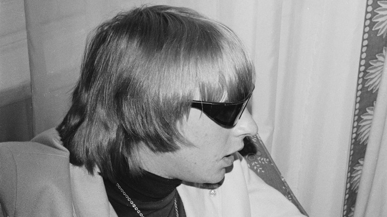 Keith Relf sitting backstage wearing sunglasses
