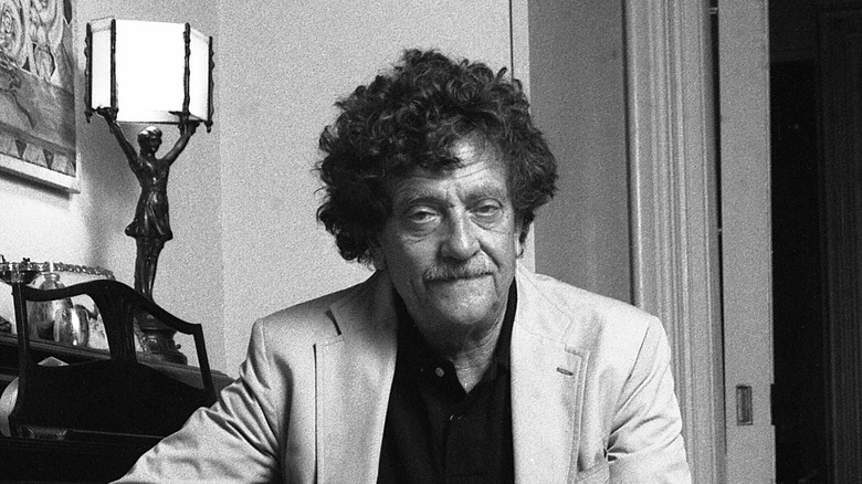 Kurt Vonnegut sits by piano