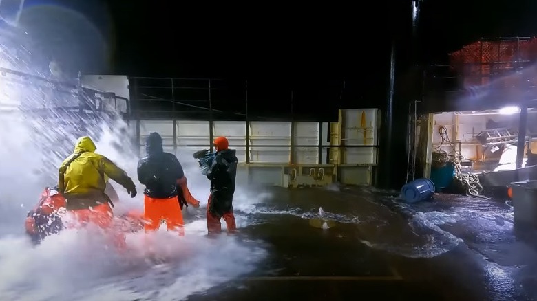 Wave crashing over crew on ship