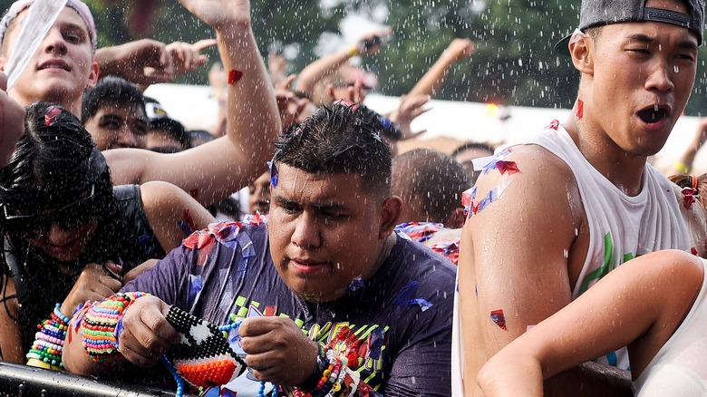 Attendee holding beads getting sprayed