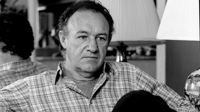 Gene Hackman sitting in a hotel room