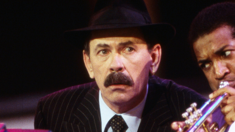 Scatman John Black hat suit moustache on stage