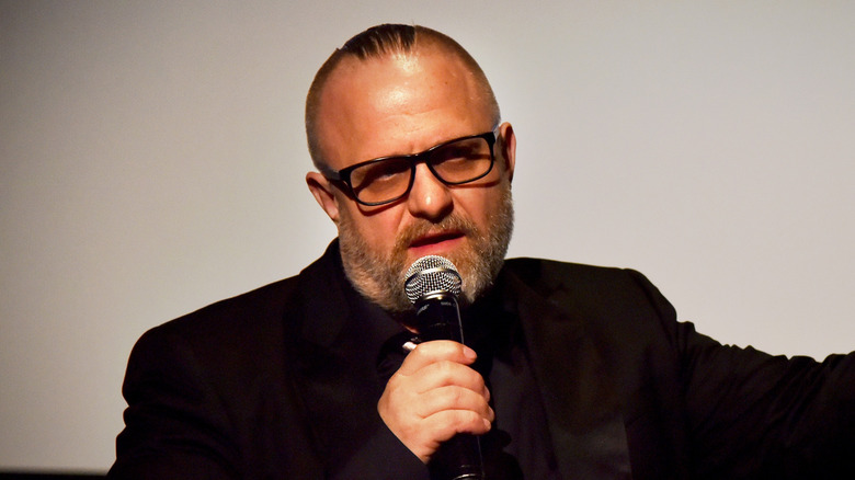 Shawn Crahan unmasked glasses holding mic