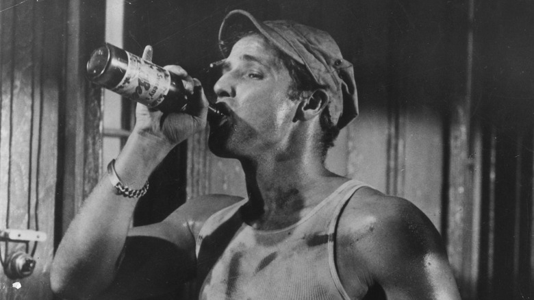 A drunk Marlon Brando swigging from a bottle in "A Streetcar Named Desire"