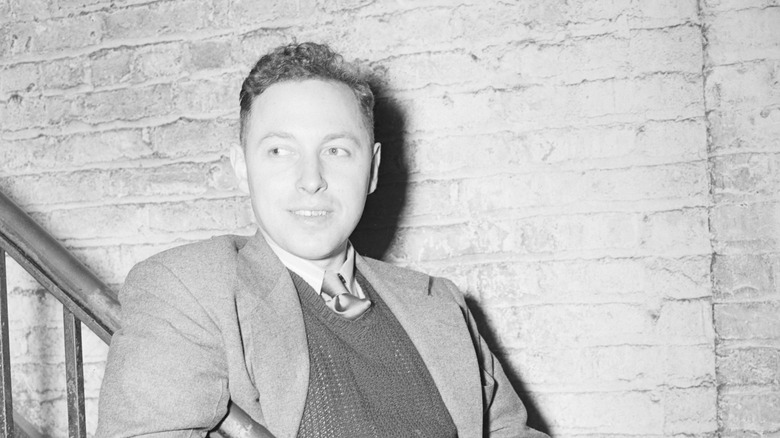 Tennessee Williams leaning against a stair rail