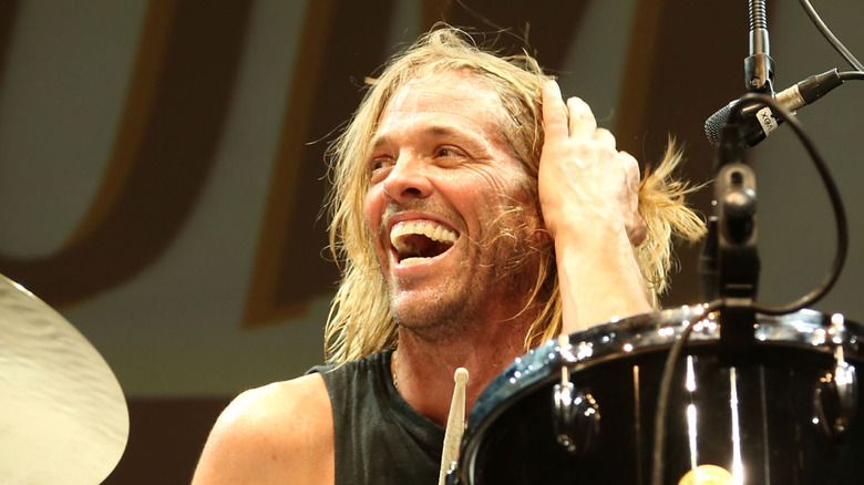 taylor hawkins smiling and touching hair behind drum kit