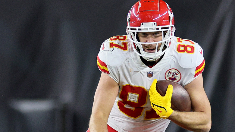 Travis Kelce running uniform football