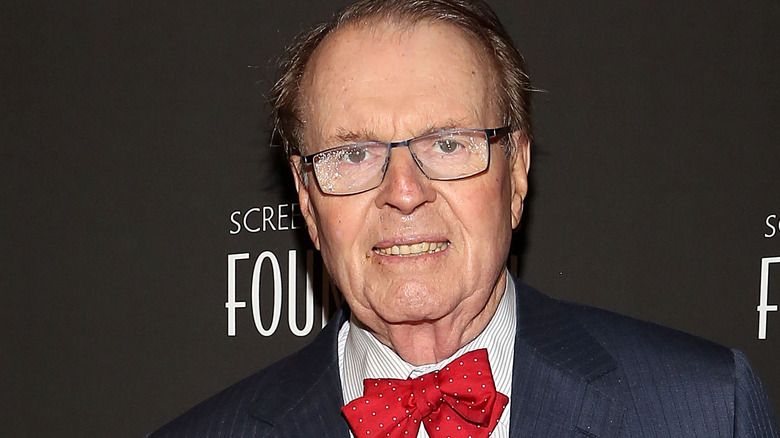 charles osgood smiling glasses suit red bowtie