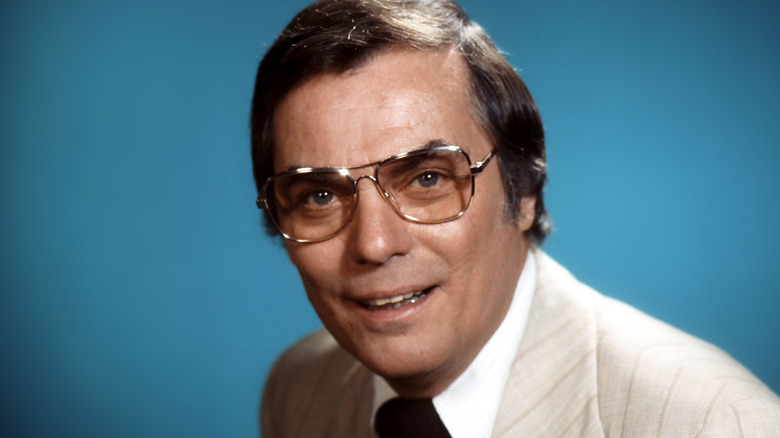 peter marshall smiling cream suit glasses