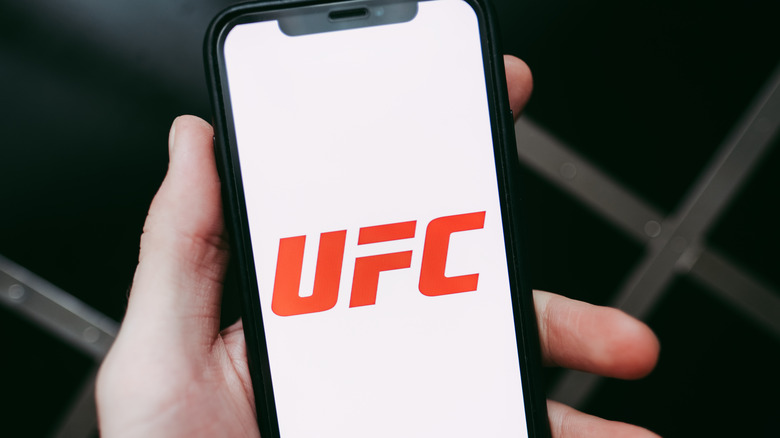 man holding phone with UFC logo