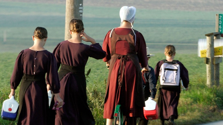 amish woman walking children to school