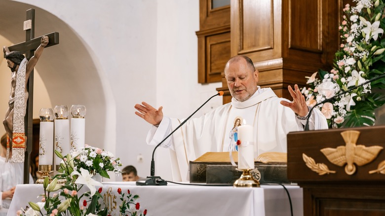 Ukrainian priest white vestment praying at altar