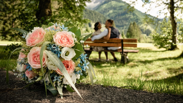 Married couple sitting behind bouquet