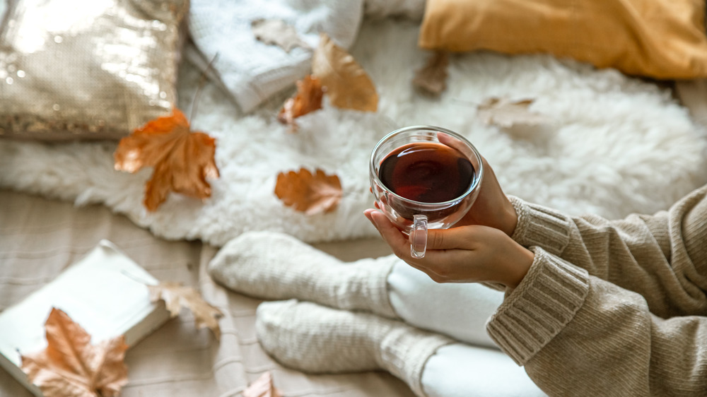 A cozy bedroom scene with pillows and tea.