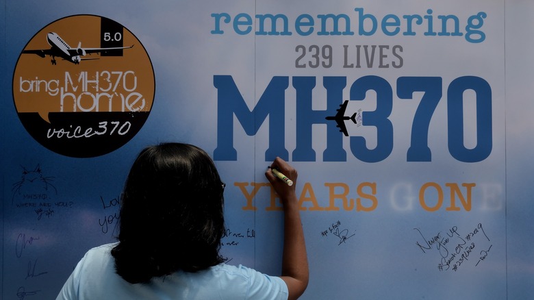 Woman signing Flight 370 memorial wall