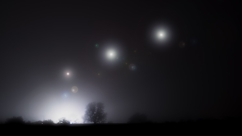 Glowing lights over nighttime rural landscape