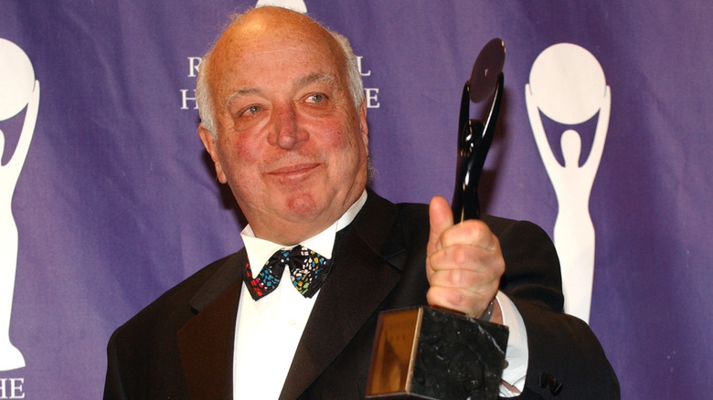 Seymour Stein holding a Rock and Roll Hall of Fame award