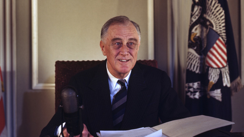 franklin roosevelt at presidential desk with paper and microphones