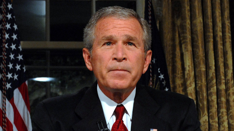 george w. bush looking up while sitting at oval office desk