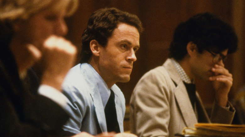 Ted Bundy in court between lawyers