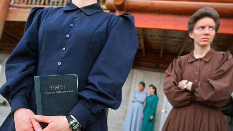 FLDS followers standing with hymn book