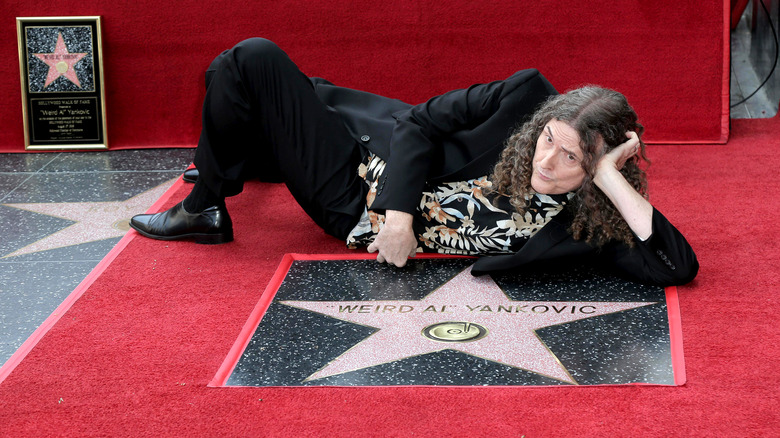 Al Yankovic posing with his Hollywood Walk of Fame star in 2018