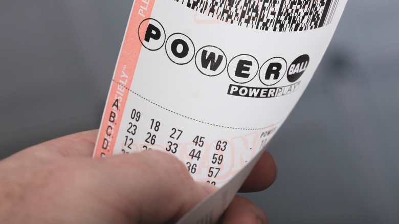 Hand holding Powerball ticket