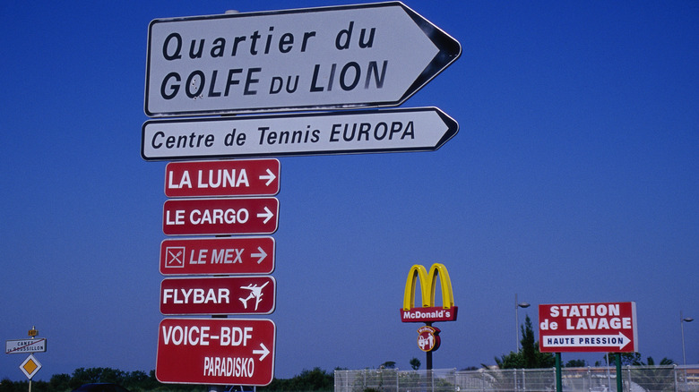 mcdonald's sign behind french road signs