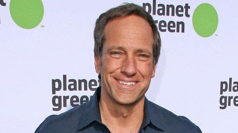 mike rowe smiling blue shirt planet green backdrop