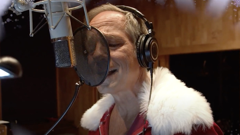 mike rowe santa suit singing into studio mic