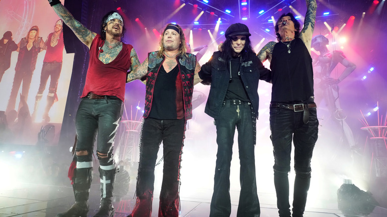 Motley Crue on stage together standing in line