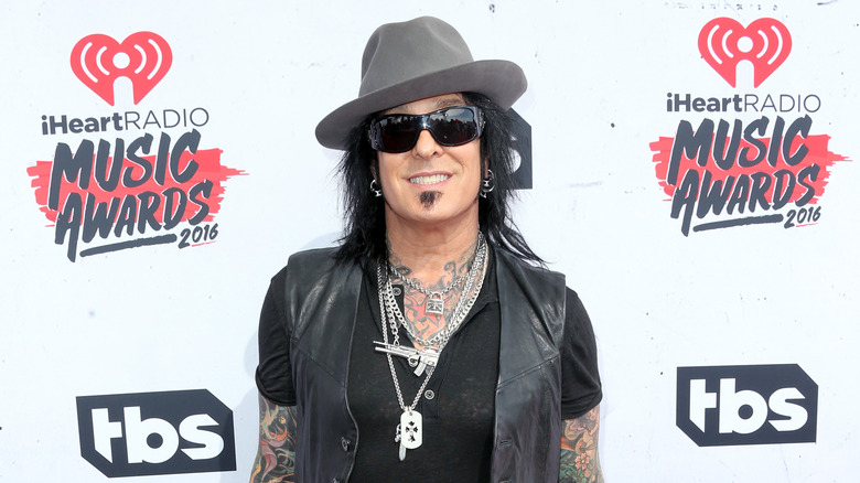 Smiling Nikki Sixx sunglasses fedora smiling at event