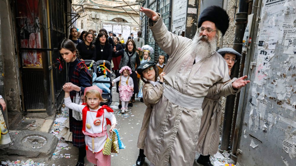 Jewish man dancing with crowd, including young children in cosume