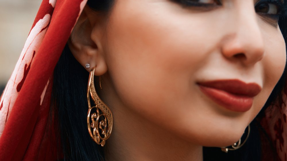 beautiful middle eastern woman wearing red scarf and earrings