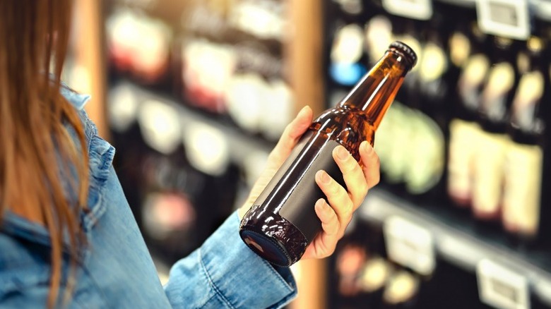 woman buying beer in liquor store