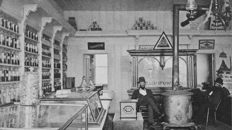 men sitting by stove in pharmacy