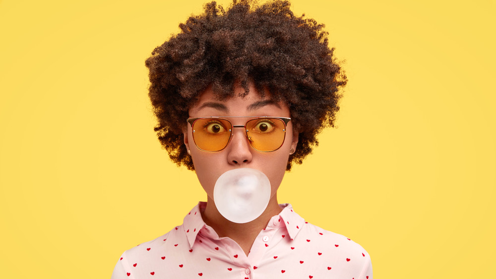 Surprised-looking woman blowing bubble