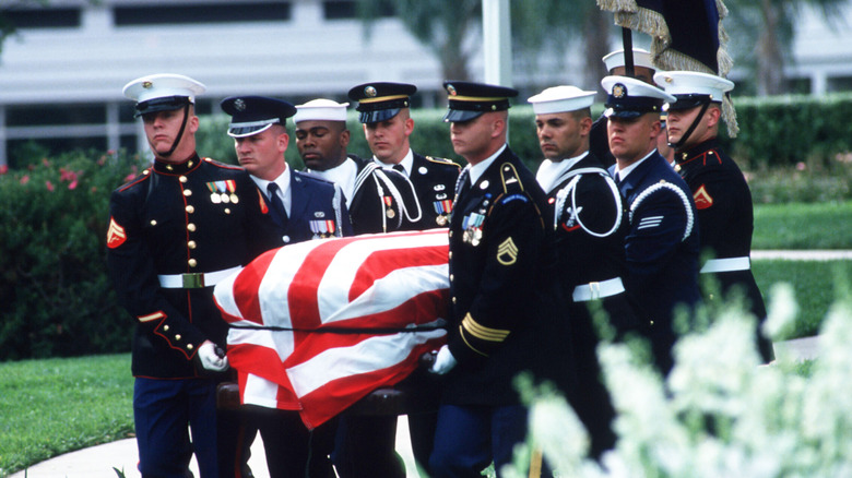 Soldiers carrying flag draped coffin