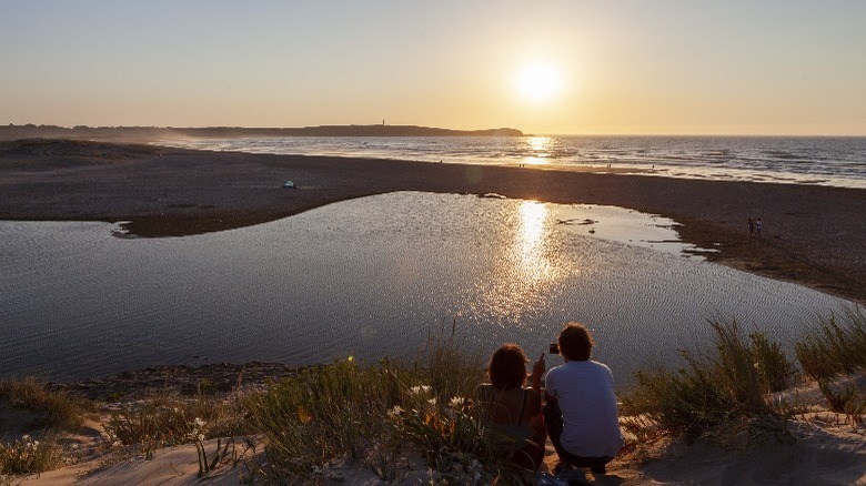 couple looking at sunset, lagoon