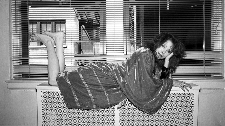 Pamela des Barres laying in a window