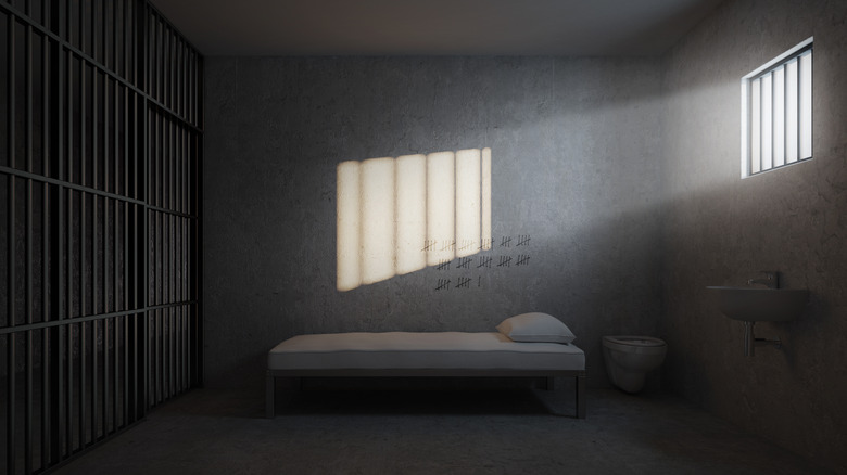 empty prison cell with a single bunk