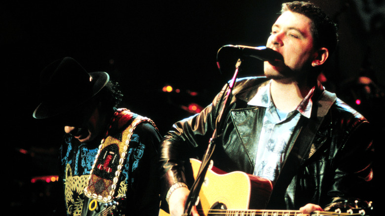 everlast and carlos santana playing guitars onstage