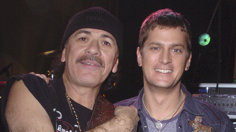 carlos santana embracing smiling rob thomas