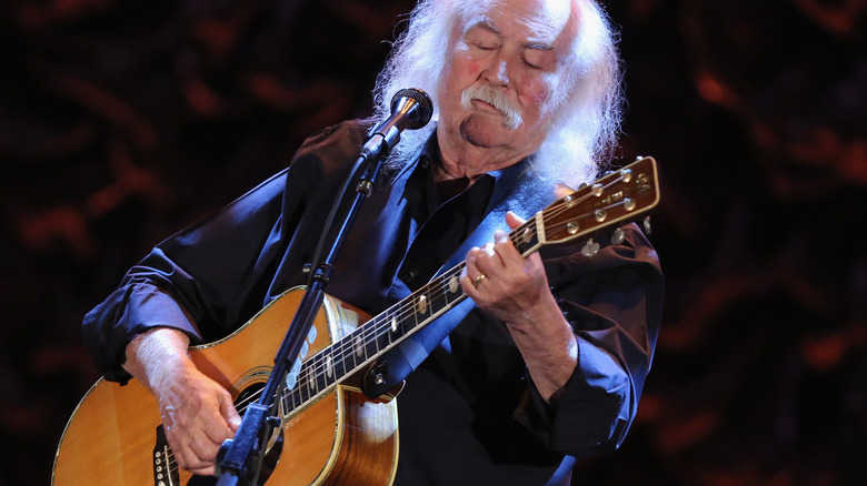 David Crosby guitar on stage mic dark suit