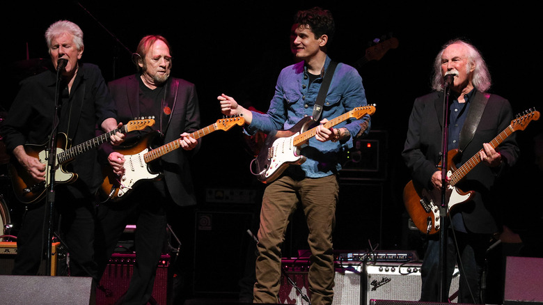 Crosby, Stills & Nash performing on stage guitars